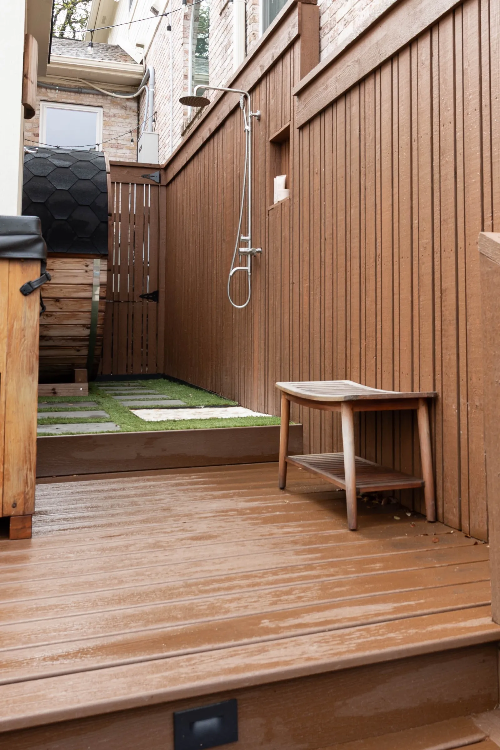 Cedar-clad backyard wellness deck with an outdoor shower and a teak bench
