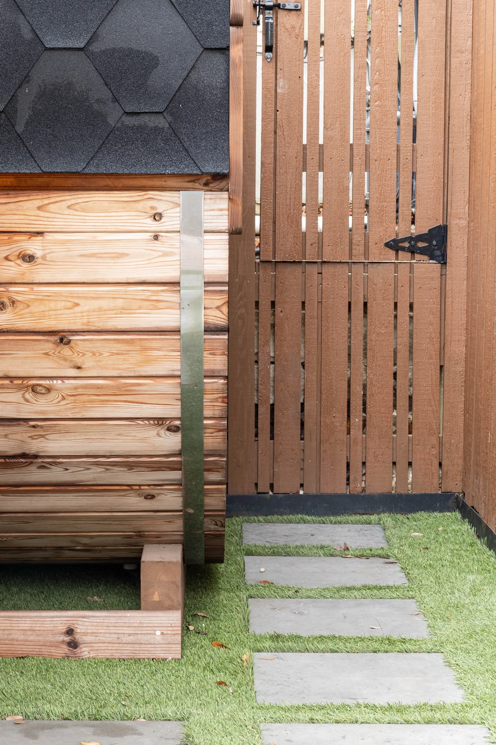 Cedar barrel sauna set against the fence at the end of the deck
