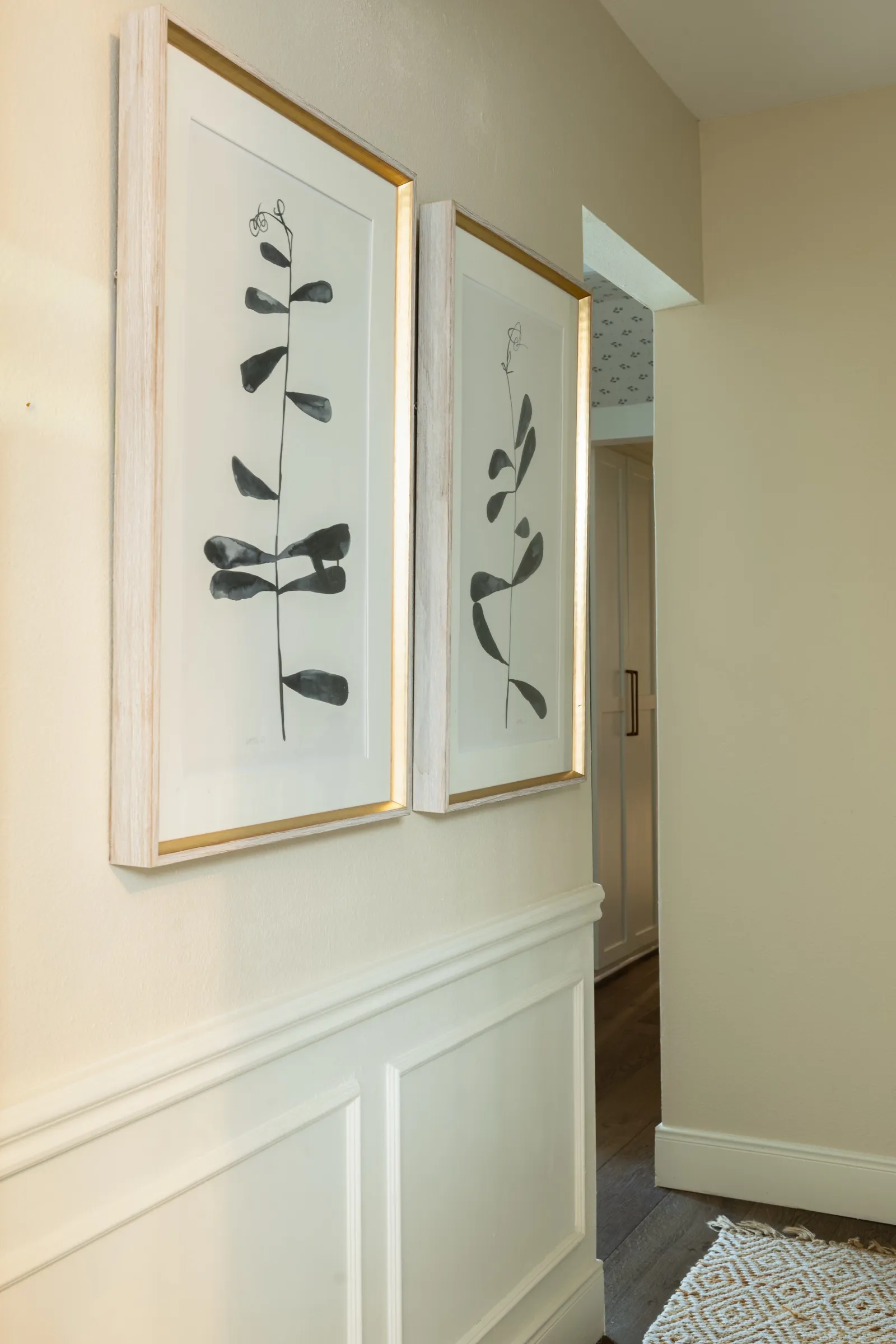 Two framed botanical prints above panelled wainscot in the hallway